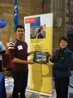 Project and Research Officer of HKETO, Doris Leung, presents a prize to the student winner of the lucky drawer during the Career Fair at the University of Sydney.